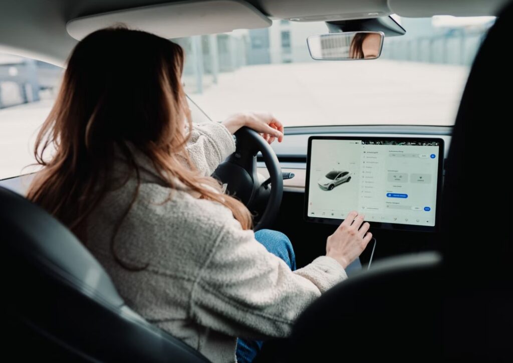 Inside Tesla displaying large LCD screen and lady
