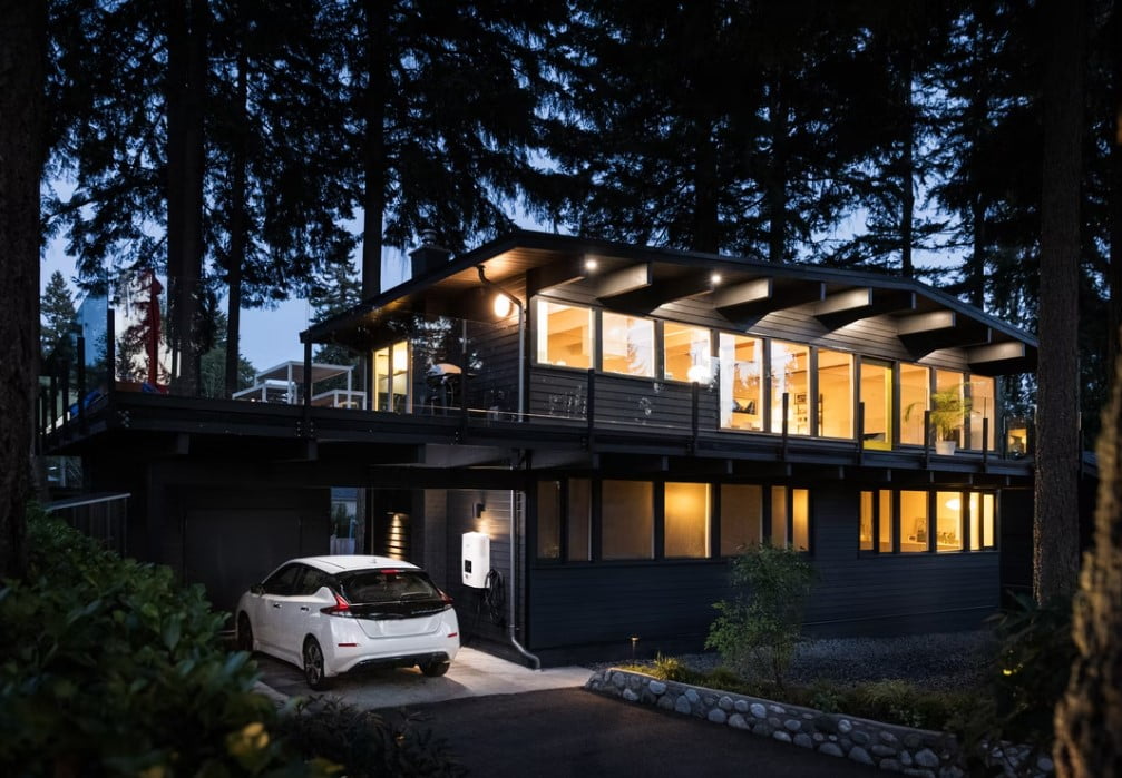 Electric Car sitting in driveway at a home during dusk